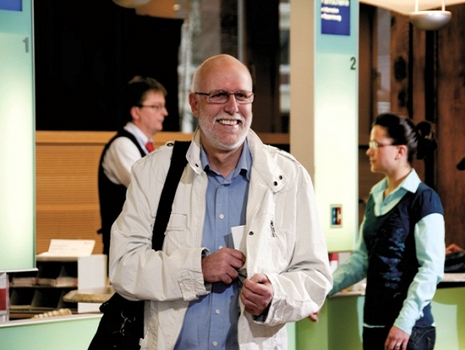 &Auml;lterer Herr steckt gerade gekauften Fahrschein in seine Innentasche